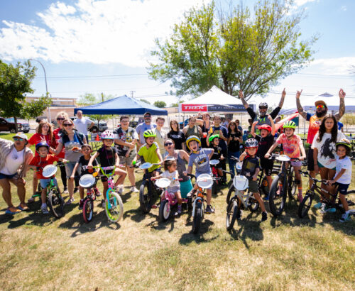 Group of youth on bikes cheering excitedly at a park