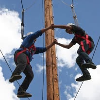 two kids holding hands balancing on a high wire