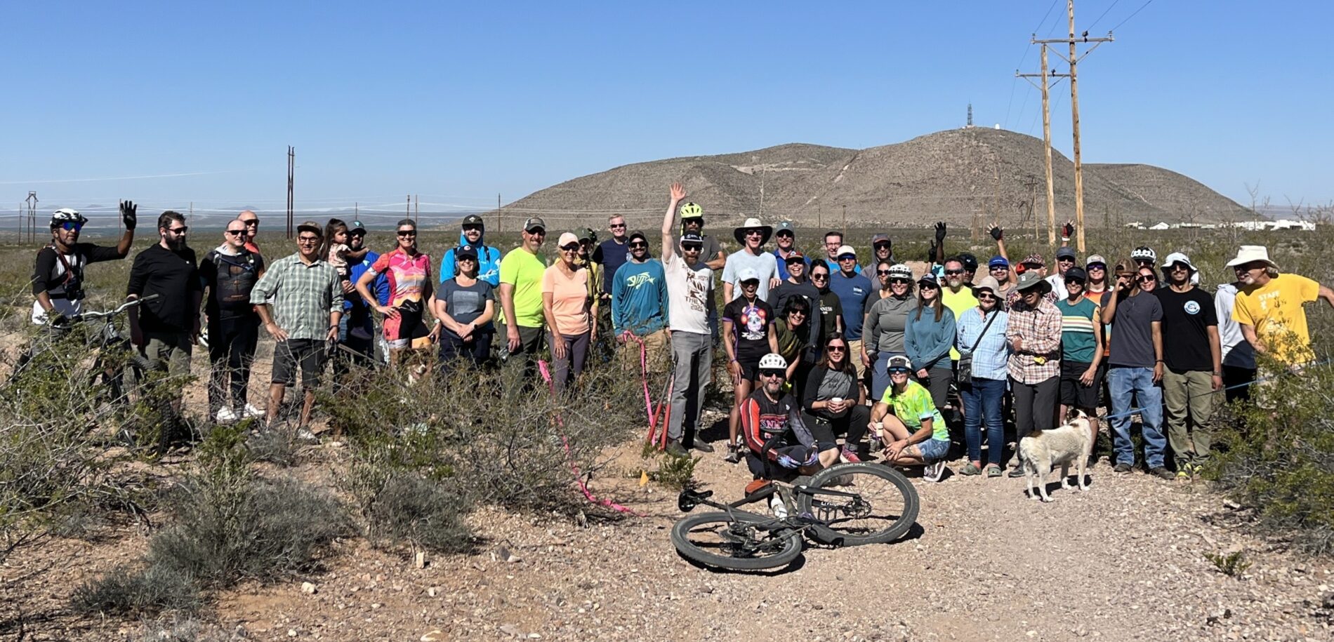 Large group of trail users posing for a group photo in the desert