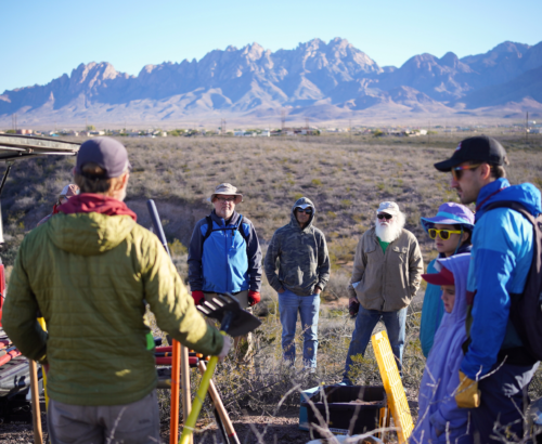 Volunteer trail workers getting a briefing with the the rugged organ mountains in the distance