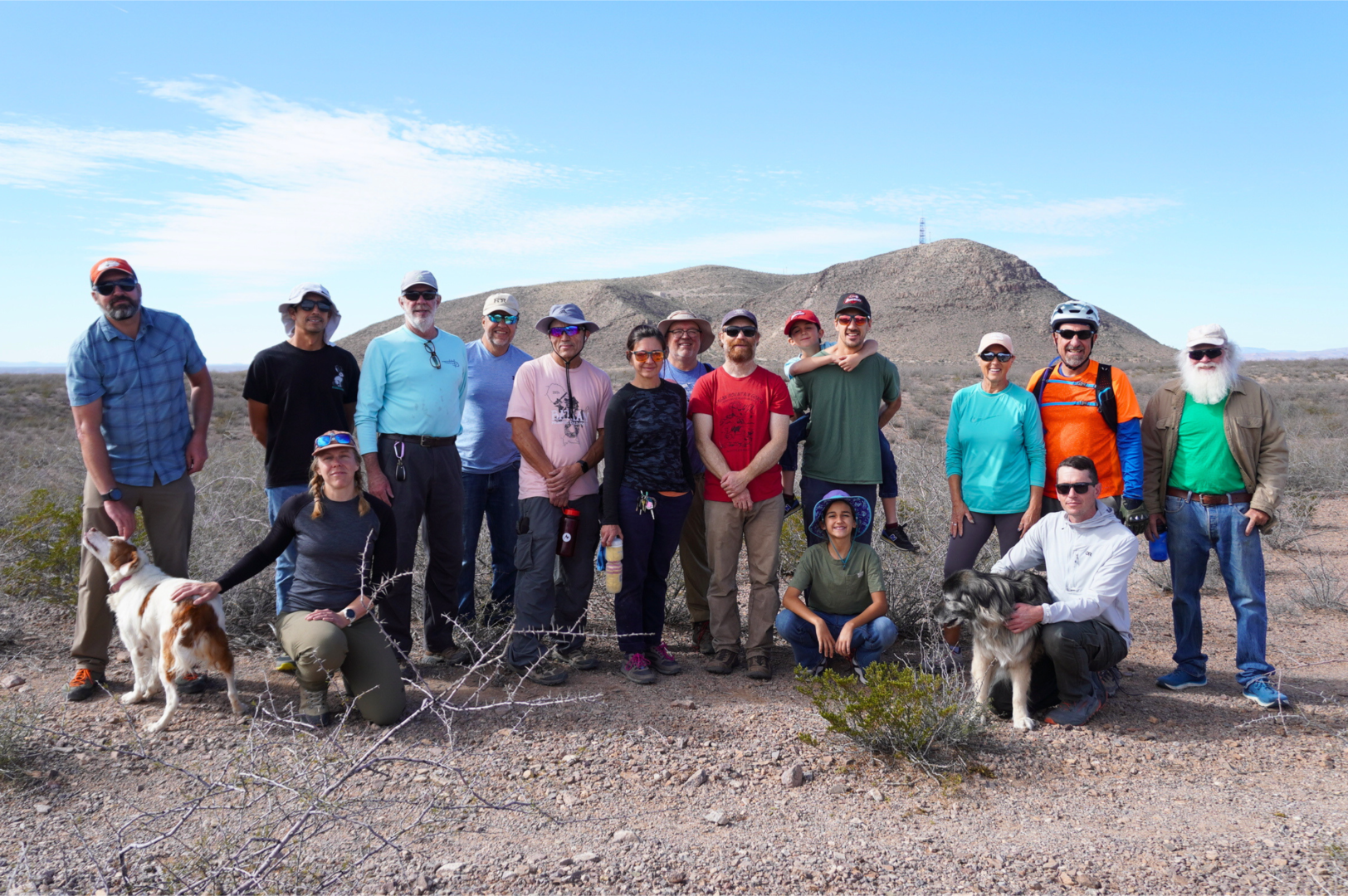 group of trail work volunteers posing and smiling in front of Tortugas mountain