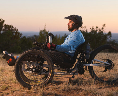 Man in an adaptive bike at sunset
