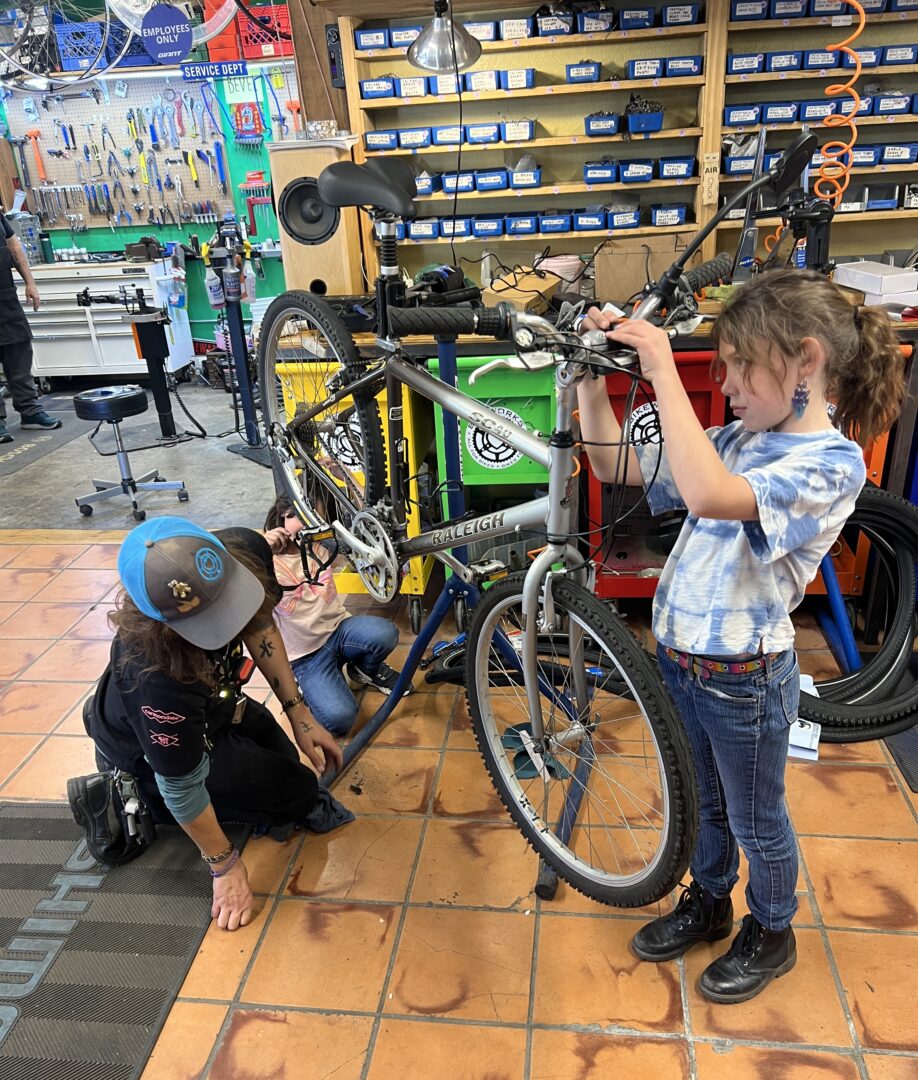 Two children working on a bike in a bike shop