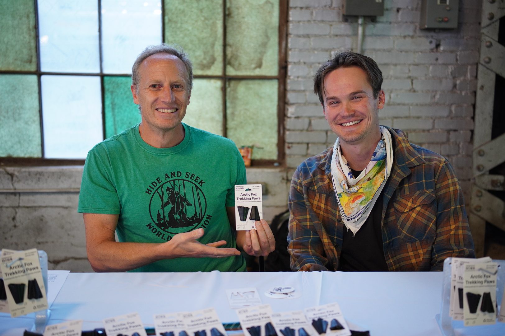 Two men sitting side by side showcasing their trekking pole tip products